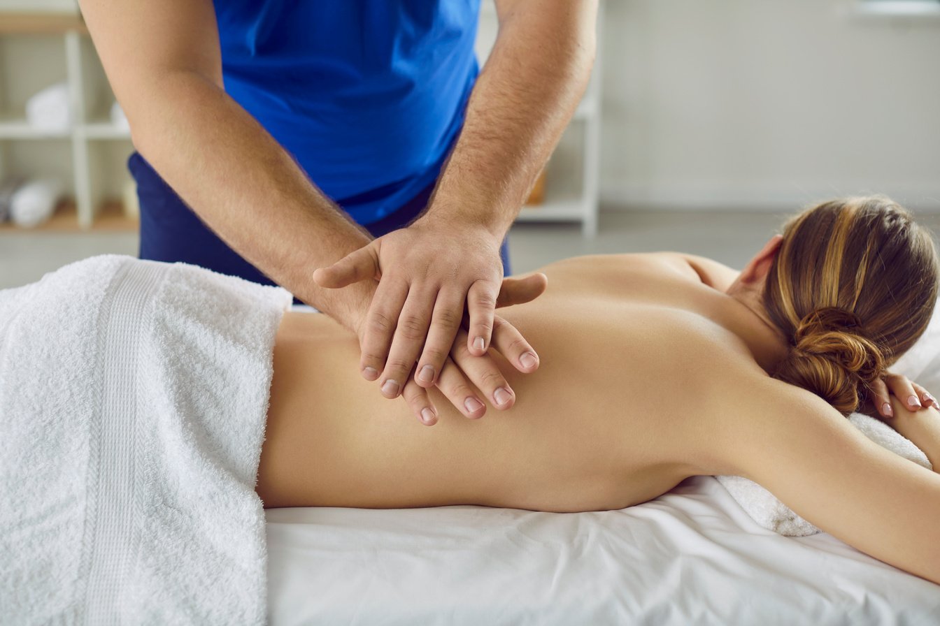 Young Woman Enjoying Relaxing, Therapeutic Back Massage at Spa Salon or Massage Room